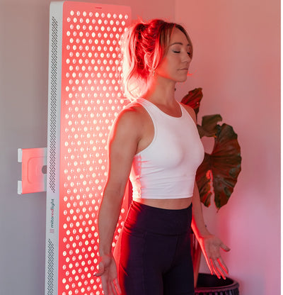 Woman is standing infront of MitoPRO™ X | Red Light Therapy Panel Series