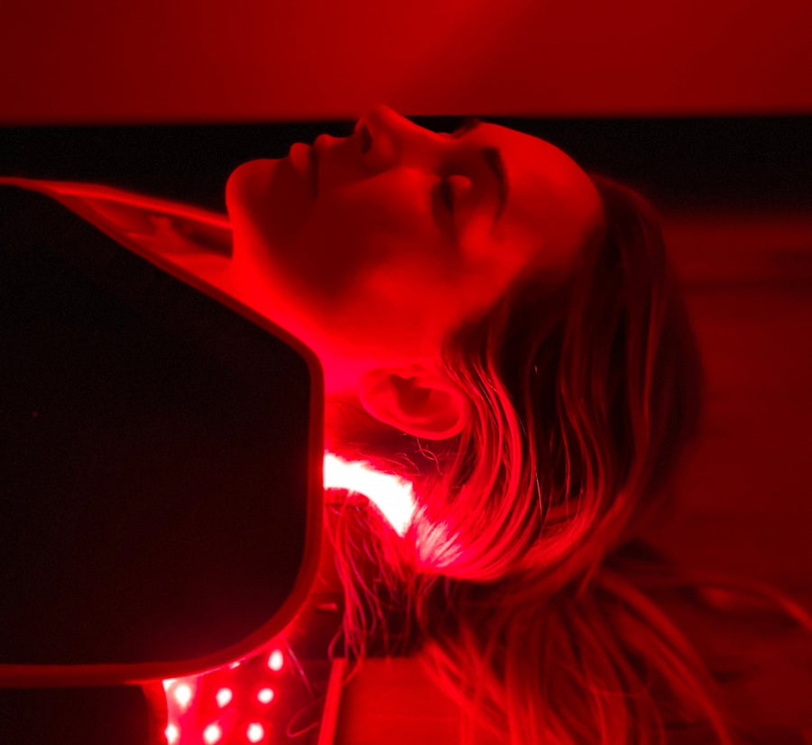 woman laying down with a orthotic red light block under her neck.