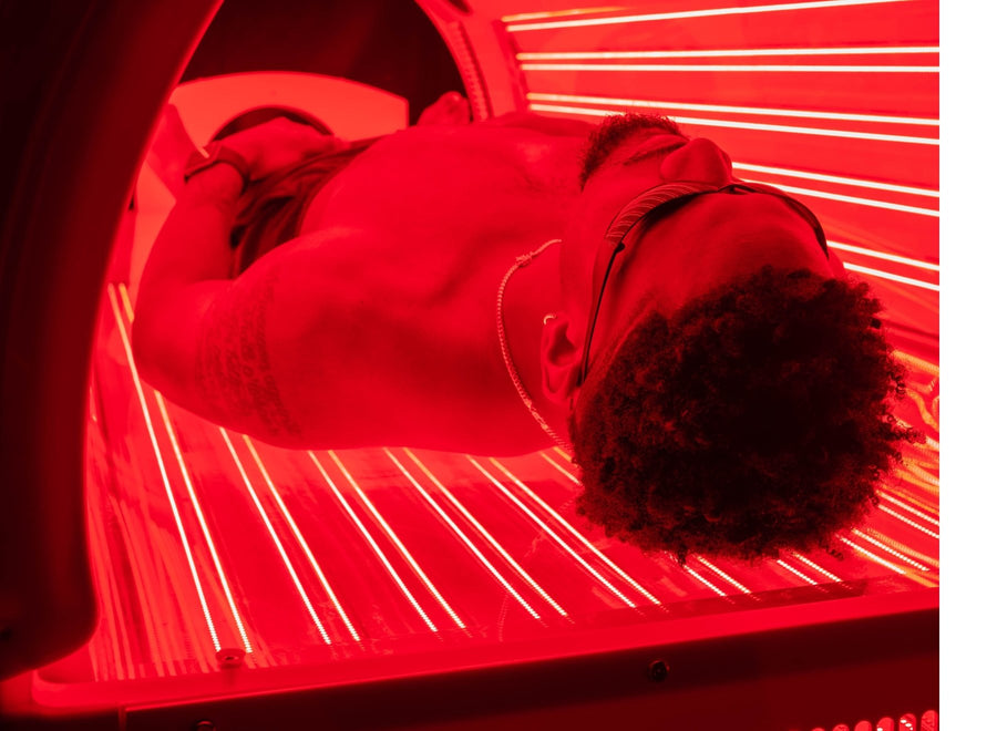 Man laying in a red light therapy bed