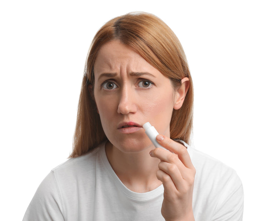 woman putting medicine on her lips.