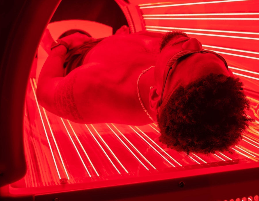 Man laying in a red light therapy bed