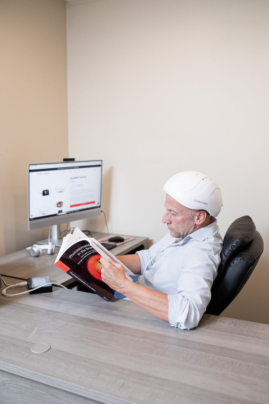 man sitting and reading while he used the MitoMIND helmet for brain entrainment.