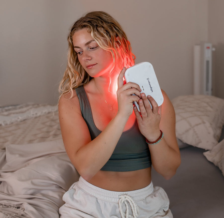 woman using red light therapy on her neck.