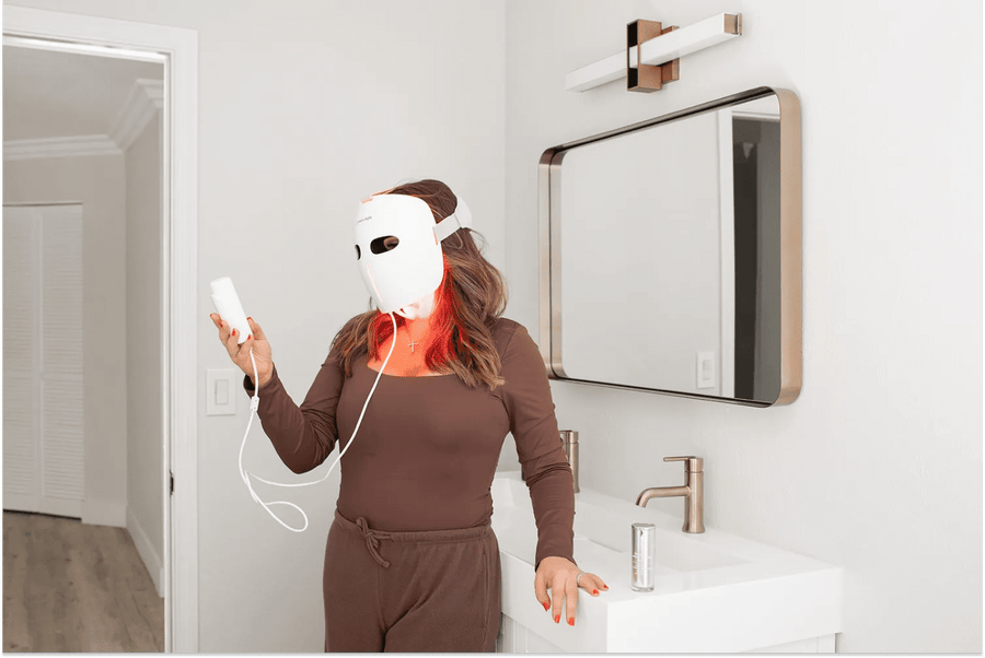 Woman using a MitoRedLight red light therapy mask at home as part of her immune support and wellness routine.